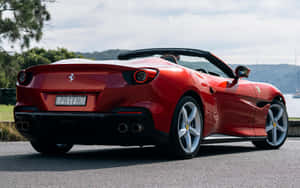 Sleek Red Ferrari Portofino Cruising On The Road Wallpaper