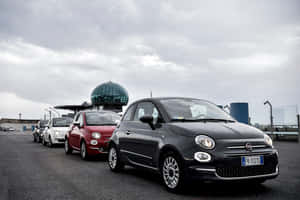 Sleek Red Fiat 500 Parked In Picturesque Venue Wallpaper