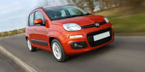 Sleek Red Fiat Panda On The Road Wallpaper