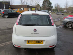 Sleek Red Fiat Punto On Open Road Wallpaper