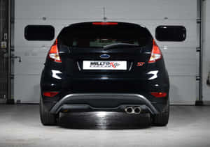 Sleek Red Ford Fiesta On A Picturesque Road Wallpaper