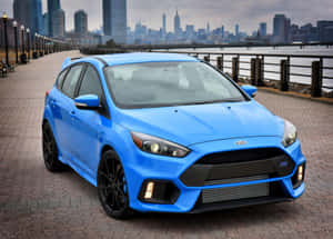 Sleek Red Ford Focus Cruising On A Scenic Road Wallpaper