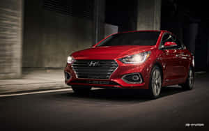 Sleek Red Hyundai Accent On The Road Wallpaper