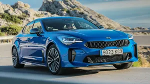 Sleek Red Kia Stinger On The Road Wallpaper