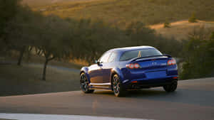 Sleek Red Mazda Rx-8 Sport Coupe On The Road Wallpaper