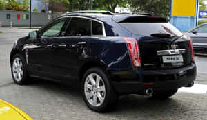 Sleek Silver Cadillac Srx On Urban Roads Wallpaper