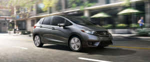 Sleek Silver Honda Fit On The Road Wallpaper