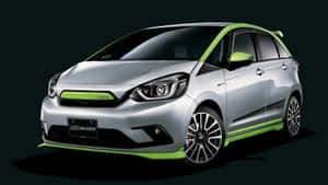 Sleek Silver Honda Fit Parked On The City Street Wallpaper