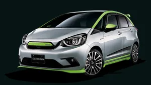 Sleek Silver Honda Fit Parked On The City Street Wallpaper