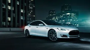 Sleek Silver Hybrid Car On The Road At Sunset Wallpaper