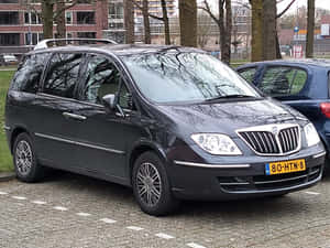 Sleek Silver Lancia Phedra On Scenic Route. Wallpaper