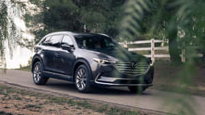 Sleek Silver Mazda Cx-9 On A Scenic Road Wallpaper