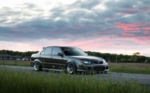 Sleek Silver Mazda Protege On The Road Wallpaper