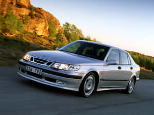 Sleek Silver Saab 9-5 In A Snowy Landscape Wallpaper