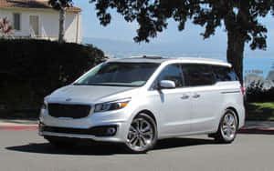 Sleek White Kia Sedona On A Scenic Road Wallpaper