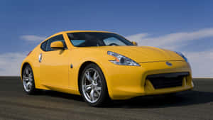 Sleek Yellow Sports Car On Open Road Wallpaper