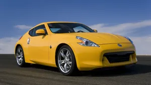 Sleek Yellow Sports Car On Open Road Wallpaper
