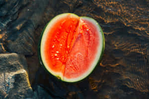 Sliced Watermelonon Rocksby Water Wallpaper