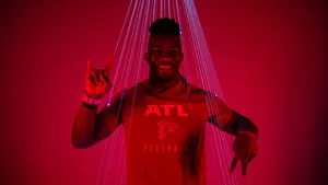 Smiling Athlete A T L Football Shirt Red Background Wallpaper