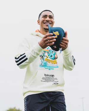 Smiling Athlete Holding Football Wallpaper