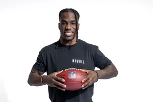 Smiling Athlete Holding Football Wallpaper