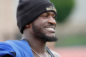 Smiling Athlete Wearing Goalie Academy Beanie Wallpaper