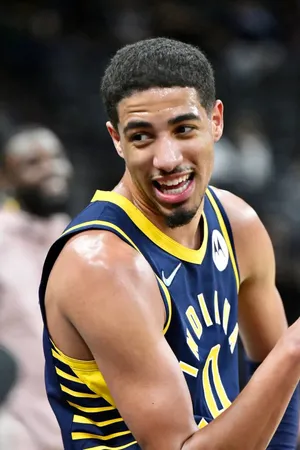 Smiling Basketball Playerin Blueand Gold Uniform Wallpaper