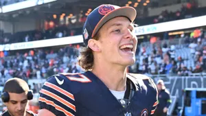 Smiling Football Player Sideline Moment.jpg Wallpaper