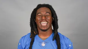 Smiling Football Playerin Blue Jersey Wallpaper