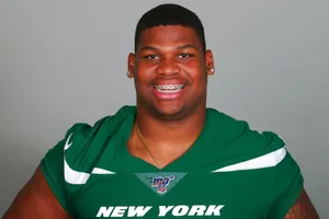 Smiling Football Playerin Green Jersey Wallpaper