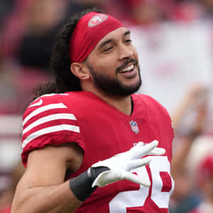 Smiling Football Playerin Red Jersey Wallpaper