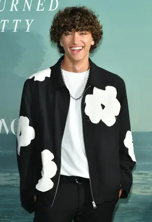 Smiling Man Floral Jacket Event Wallpaper