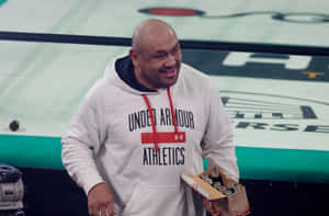 Smiling Man Holding Boxat Sports Event Wallpaper