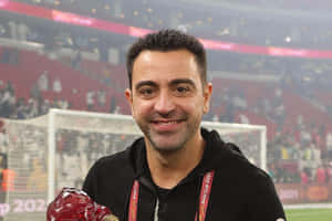 Smiling Man Holding Trophyat Stadium Wallpaper