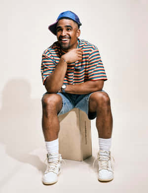 Smiling Man Sitting Casual Outfit Wallpaper