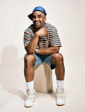 Smiling Man Sitting Casual Outfit Wallpaper