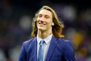 Smiling Manin Blue Suitwith Air Pods Wallpaper