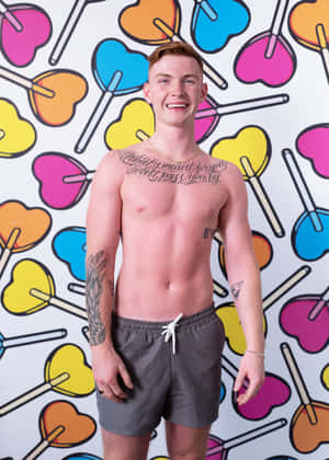Smiling Manwith Tattoos Against Colorful Backdrop Wallpaper