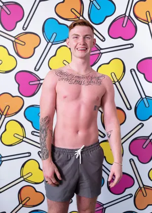 Smiling Manwith Tattoos Against Colorful Backdrop Wallpaper