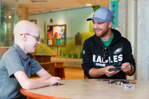 Smiling Visitor Playing Cards With Child Wallpaper