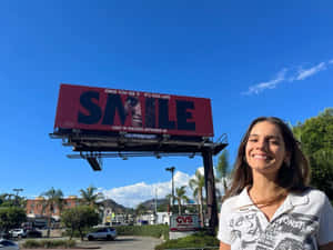 Smiling Woman Billboard Movie Promotion Wallpaper