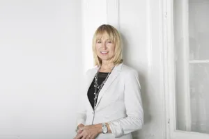 Smiling Woman Leaning Against White Wall Wallpaper