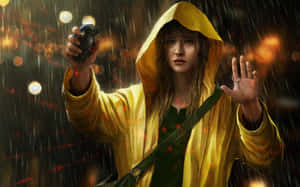 Smiling Woman Wearing A Yellow Raincoat Outdoors Wallpaper