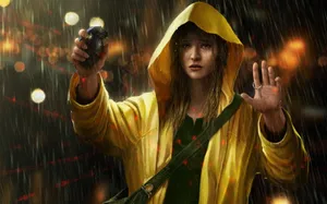 Smiling Woman Wearing A Yellow Raincoat Outdoors Wallpaper