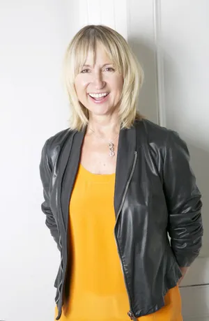 Smiling Womanin Yellow Topand Leather Jacket Wallpaper