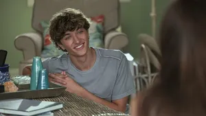 Smiling Young Man At Table Wallpaper