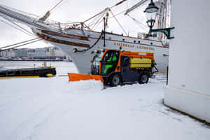 Snowplow Clearing A Road In A Winter Landscape Wallpaper