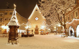 Snowy_ Evening_ Town_ Square Wallpaper