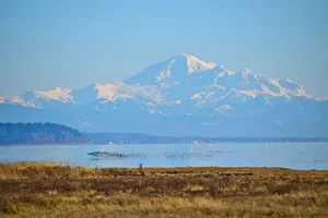 Snowy_ Mountain_ View_ Across_ Waterbody Wallpaper