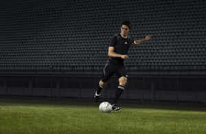 Soccer Player Dribblingin Stadium Wallpaper